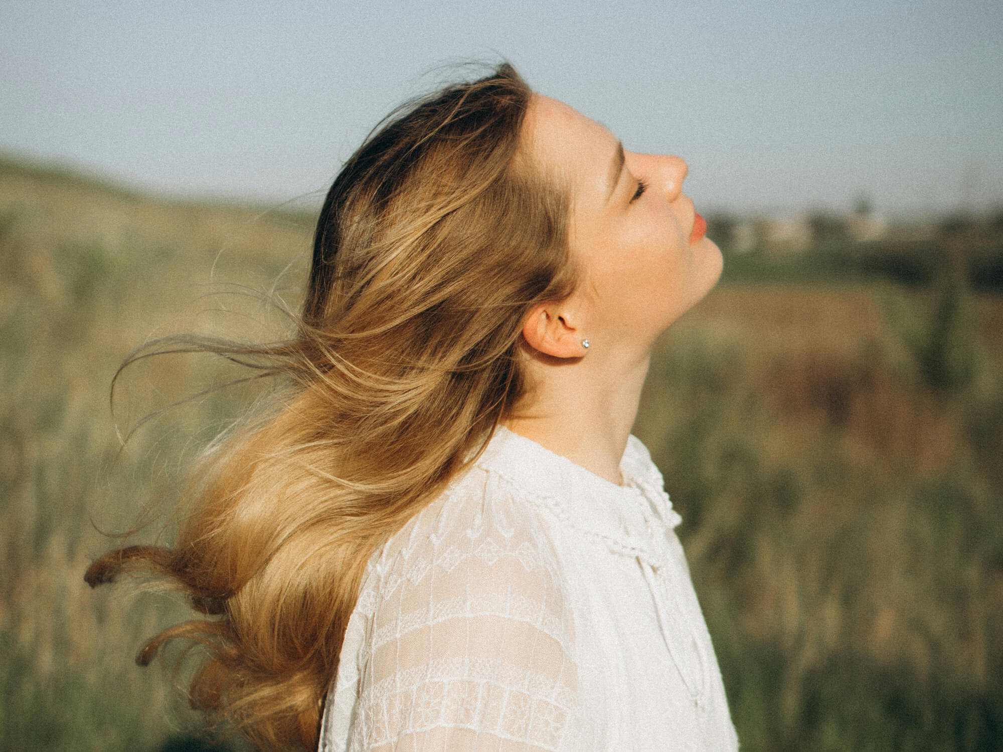 Junge Frau geniesst Selfcare-Moment in der Natur